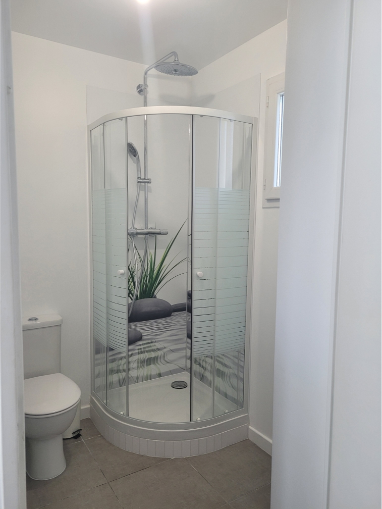 Salle de bain classique, carrelage blanc avec pommeau en hauteur.