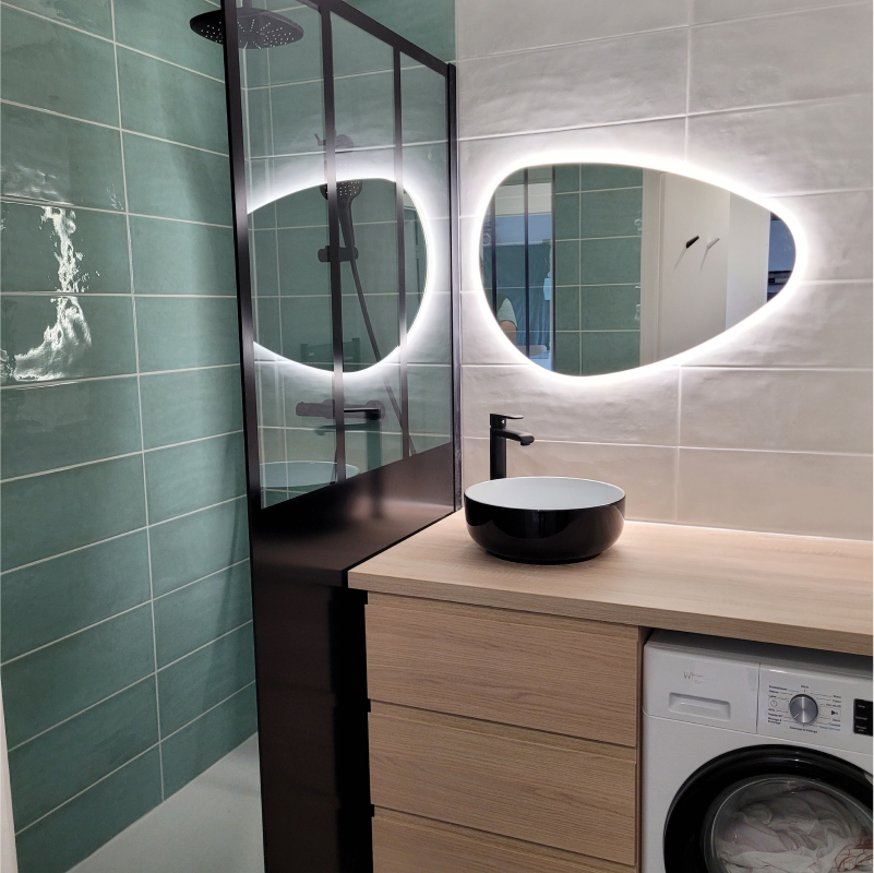 Salle de bain design, carrelage blanc et vert avec douche à l'italienne et pommeau en hauteur, et meuble en bois.