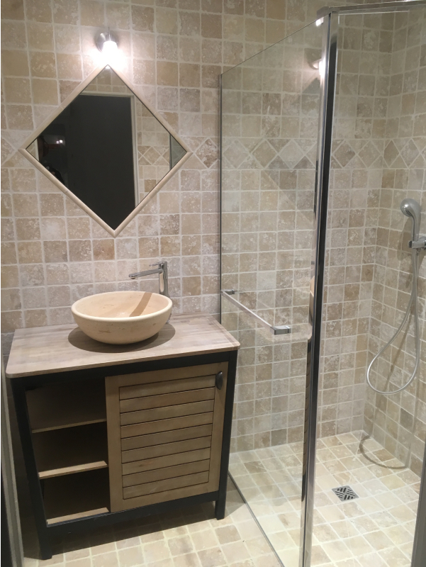 Salle de bain avec douche à l'italienne et carrelage beige.